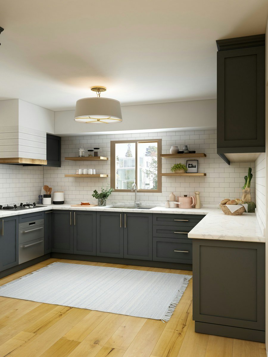 Bright modern kitchen with charcoal cabinets, tiled walls and marble counters