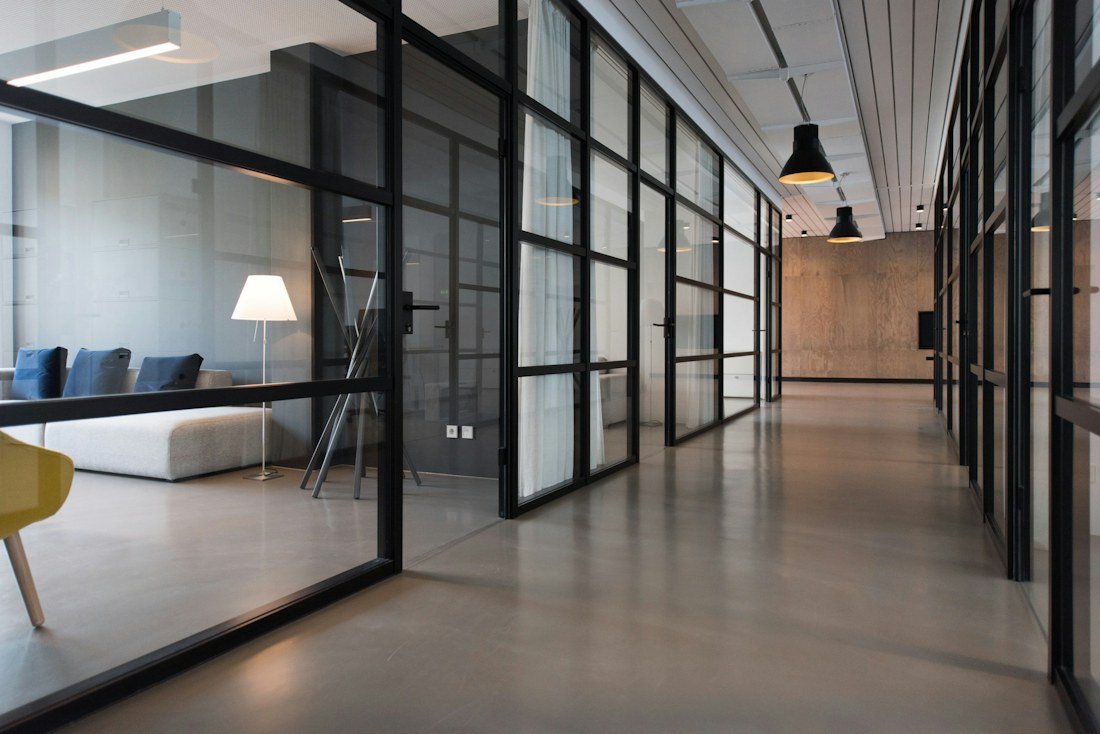 Glass-partitioned contemporary office with a bright open-plan corridor